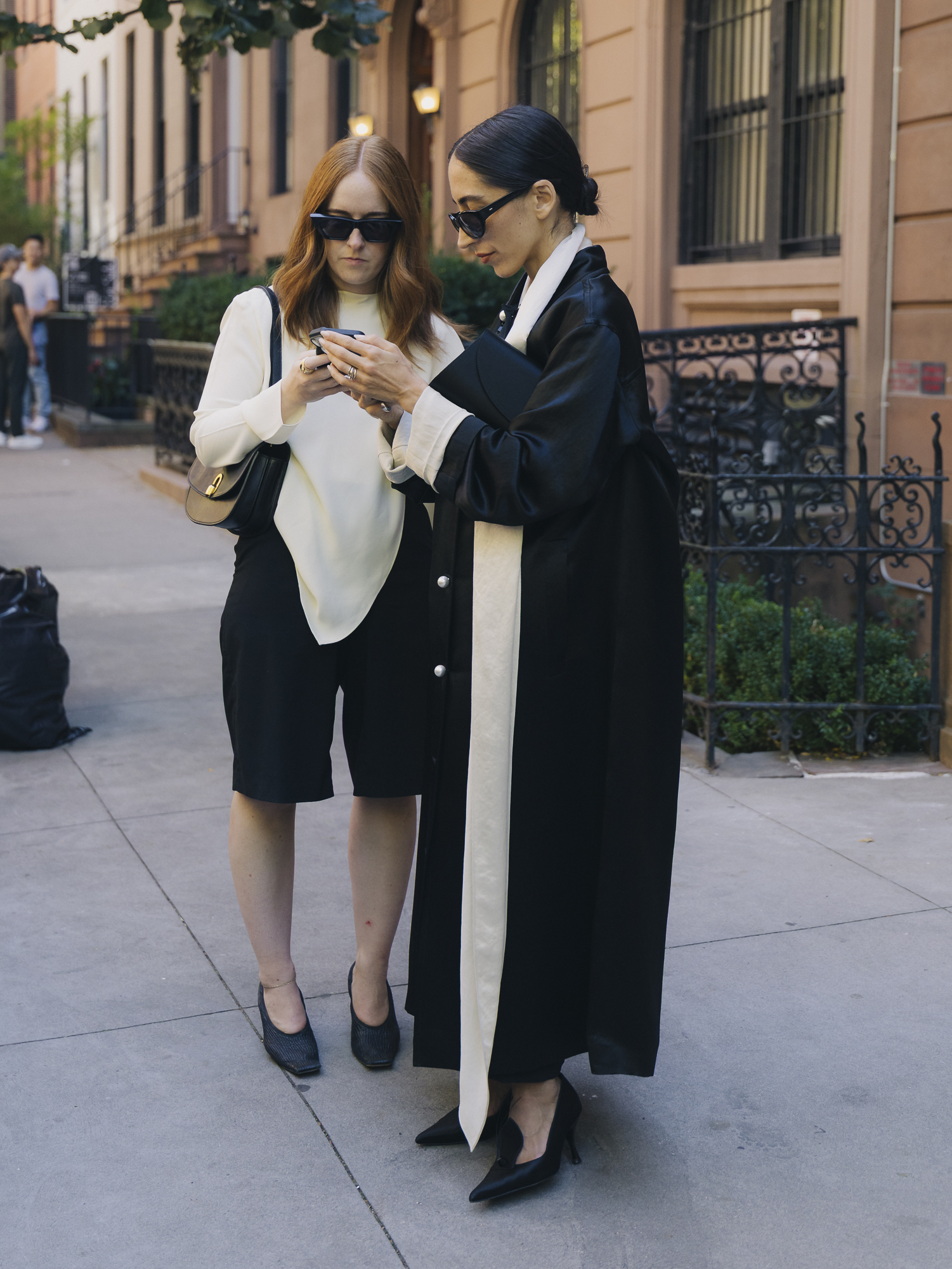 A guest wearing a black satin coat with Gia Borghini Renata heels during New York Fashion Week.