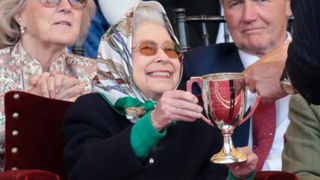 Queen Elizabeth II receives the winners cup at The Royal Windsor Horse Show at Home Park on May 13, 2022 in Windsor