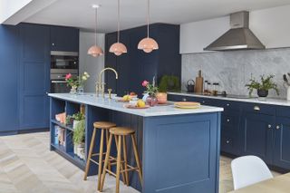 Kitchen extension with large island with bar stools and pendant lights