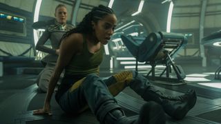 Gaal sits and gasps for breath as Demerzel kneels behind her on a spaceship in Foundation season 3 episode 6