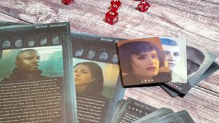 Case files, cards, and dice from the Blade Runner RPG Starter Set on a wooden background