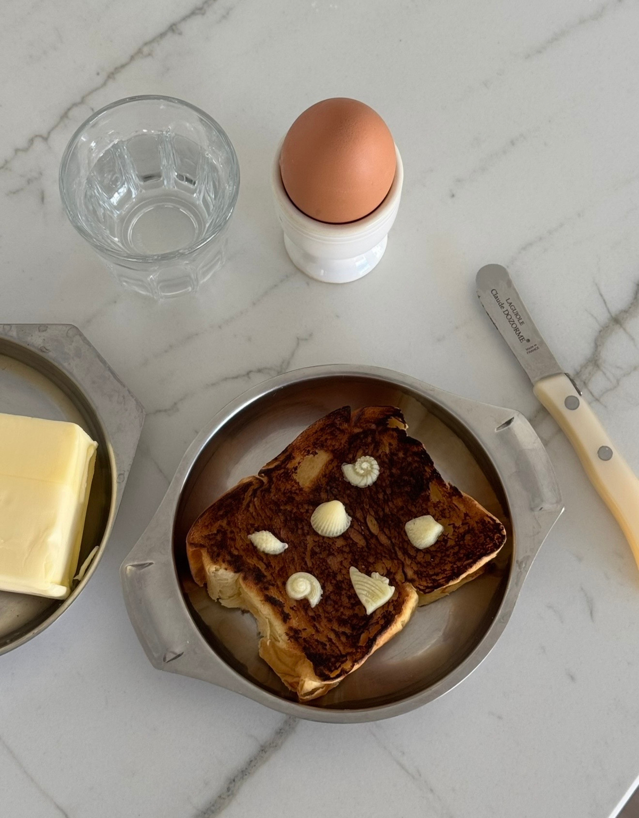 butter molds in seashell shapes sit on a piece of toast
