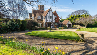 Aldwick Bay Estate in West Sussex, mock-Tudor house with sunny front garden.