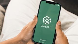 The ChatGPT logo is seen on an iPhone held by someone off camera.