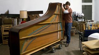 Man moving a grand piano