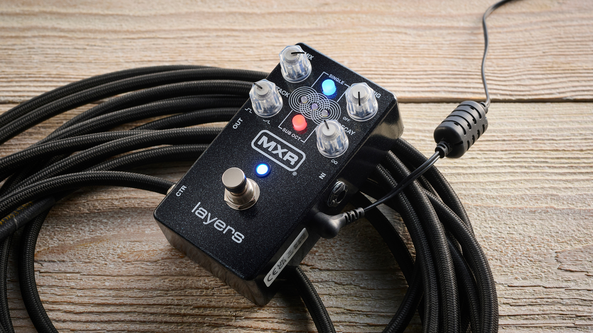 MXR Layers pedal in metallic black finish with clear controls pictured on wood floor with coiled guitar cable