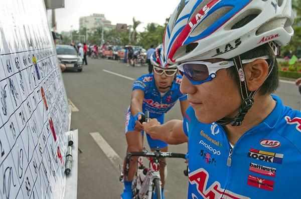 Mmm...not a bad signature if I don't say so myself: Aisan Racing Team's Nakajima Yasuharu checks out his signature and hands the pen to a teammate in Danzhou.