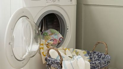  white washing machine and bucket with cloths