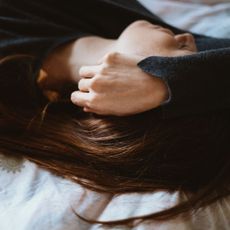 Chronic fatigue syndrome symptoms: A woman lying exhausted on a bed