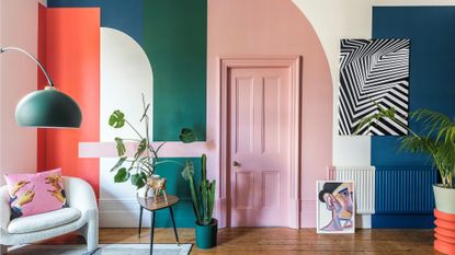 a living room painted in green, blue, pink and orange