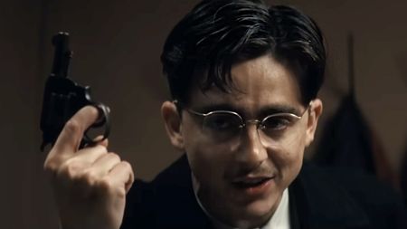 Timothee Chalamet holding a gun in A24's box office hit, Marty Supreme (2025).