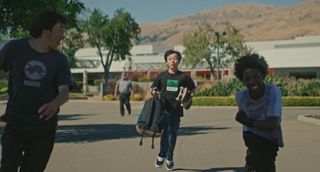 chris played by izaac wang as he's skateboarding with his friends in a parking lot in didi