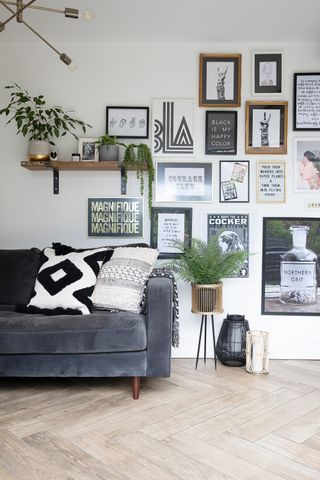 A living room with grey sofa and aztec style patterned cushions with gallery wall art