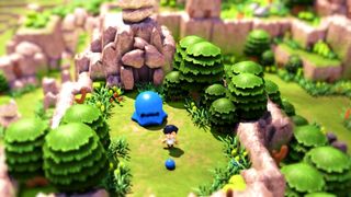 Littlelands screenshot showing a small boy atop a colorful grassy hill standing in front of a massive blue slime creature
