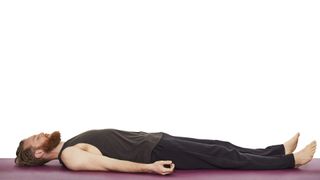 Yoga teacher Nick Higgins demonstrates corpse pose