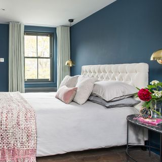 bedroom with blue walls and bed with pillows