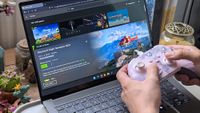 Hands holding a pink‑and‑white Xbox controller in front of an ASUS laptop displaying the GeForce NOW page for Microsoft Flight Simulator 2024, showing a green &ldquo;Play&rdquo; button.