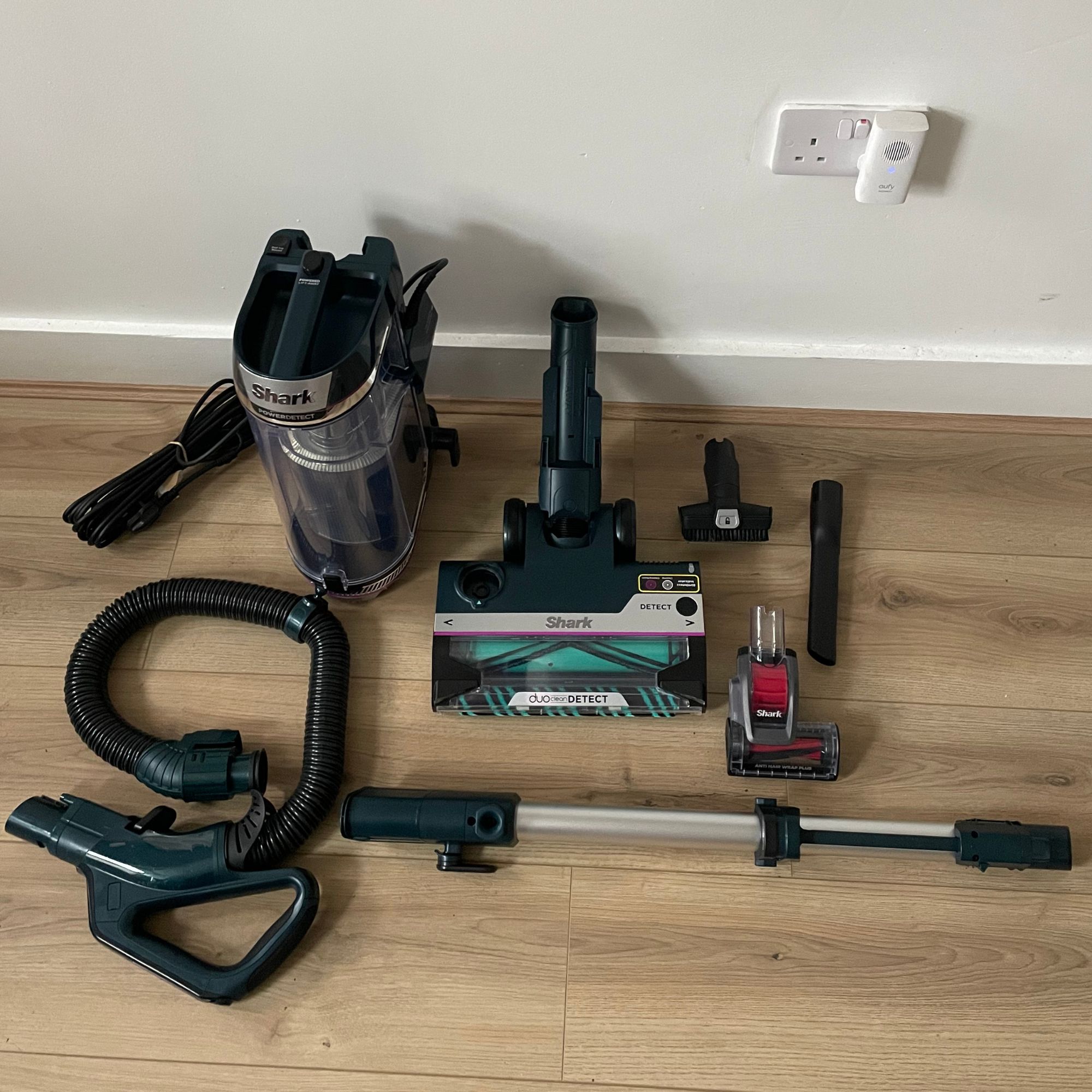 Components of the Shark PowerDetect Powered Lift-Away Upright Pet Vacuum Cleaner AZ3900UKT laying on wood-effect flooring