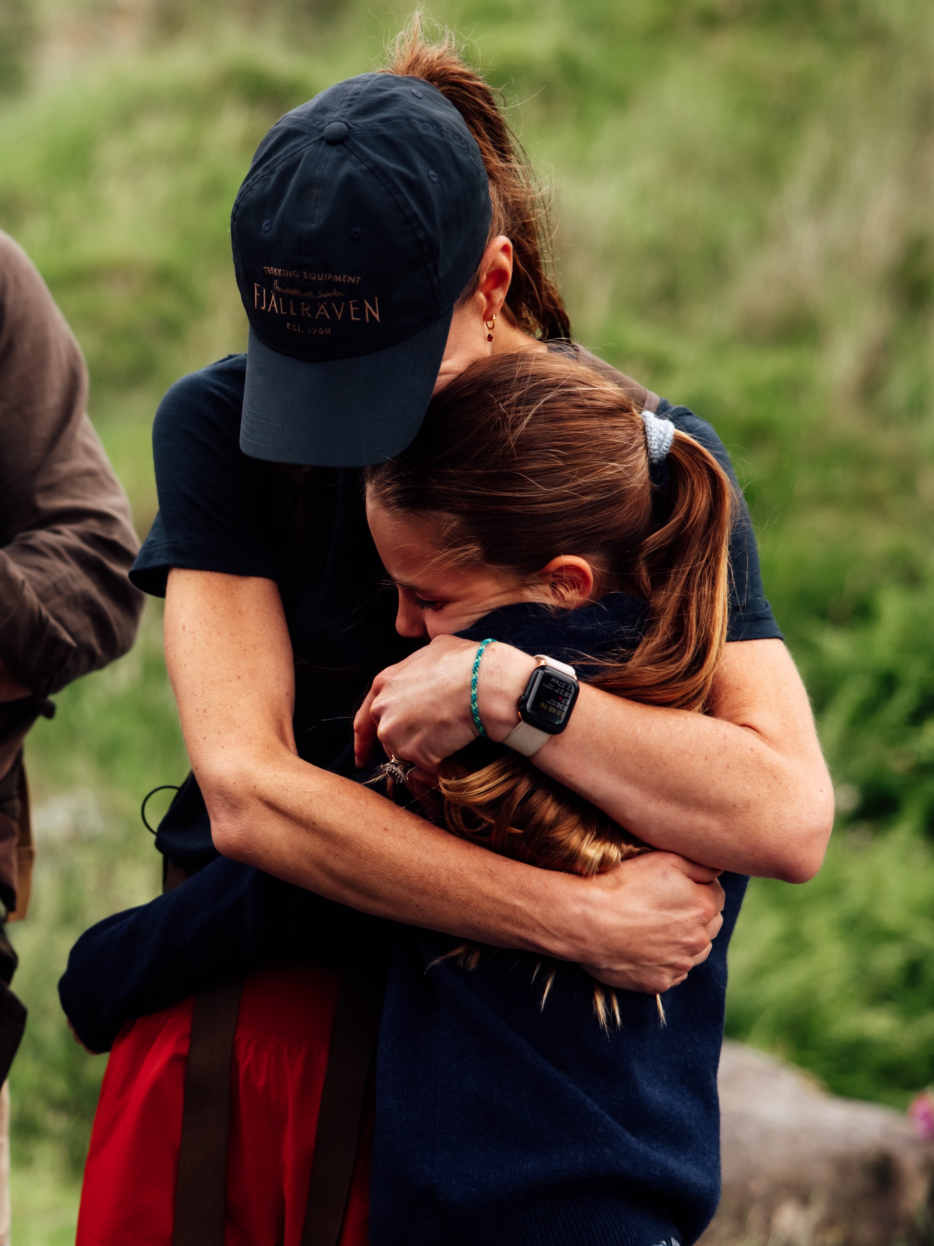 Princess Kate, wore is wearing red shorts and navy baseball cap, is greeted by her three children, Princess Charlotte, Prince George, and Prince Louis, who all wear matching denim jeans