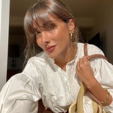 Influencer wears a broderie anglaise blouse.