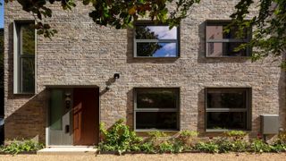 A stone townhouse with a gravelled driveway