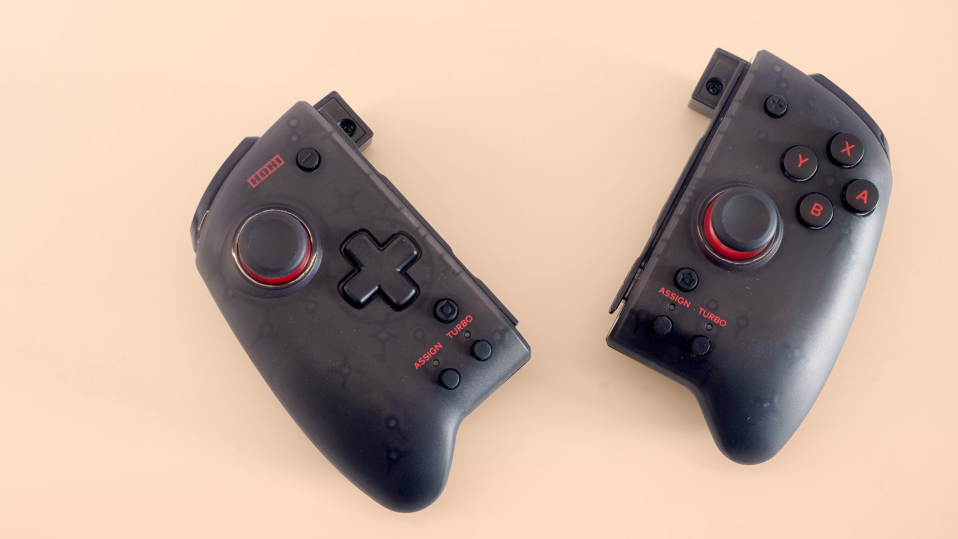 Två stycken Hori Split Pad Pro-kontroller ligger på en beige yta.