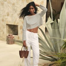 J.Crew model wearing a striped shirt with white pants