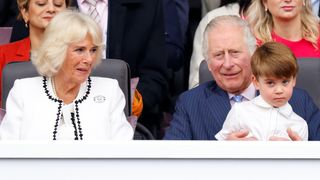 Queen Camilla looks on as Prince Louis sits on King Charles's lap as they attend the Platinum Pageant