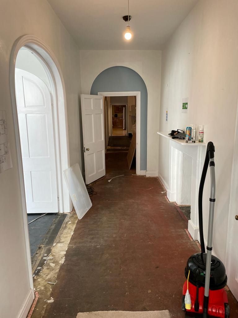The hallway before the renovation with bare floor and walls