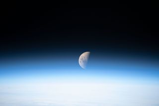 The first-quarter moon rises over Earth's thin, blue atmosphere in this photo taken by an astronaut at the International Space Station. One of the six Expedition 61 crewmembers on board captured this view on Oct. 5, when the moon was waxing. It became full on Sunday (Oct. 13), and the moon will once again be half illuminated on Monday (Oct. 21) when it reaches its third quarter phase.