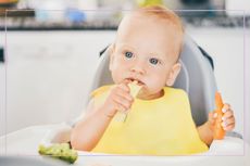Baby led weaning illustrated by baby eating veg