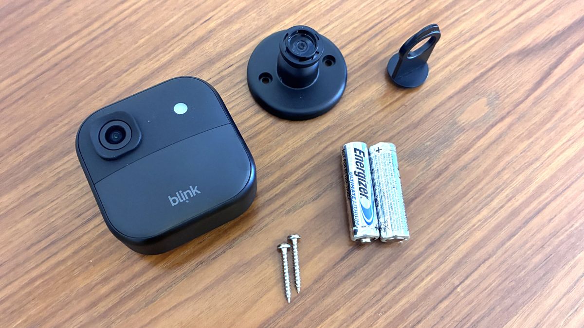 Blink Outdoor 2K+ security camera with mount and batteries on table