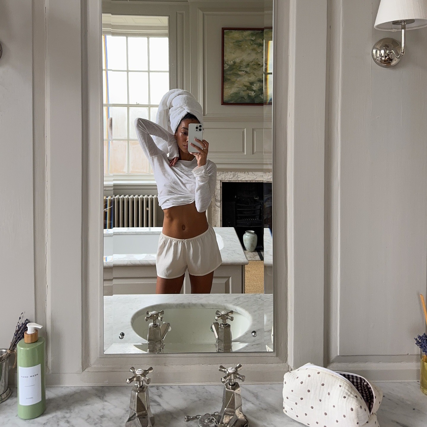 Creator @amaka.hamelijnck taking a mirror selfie with glowing skin