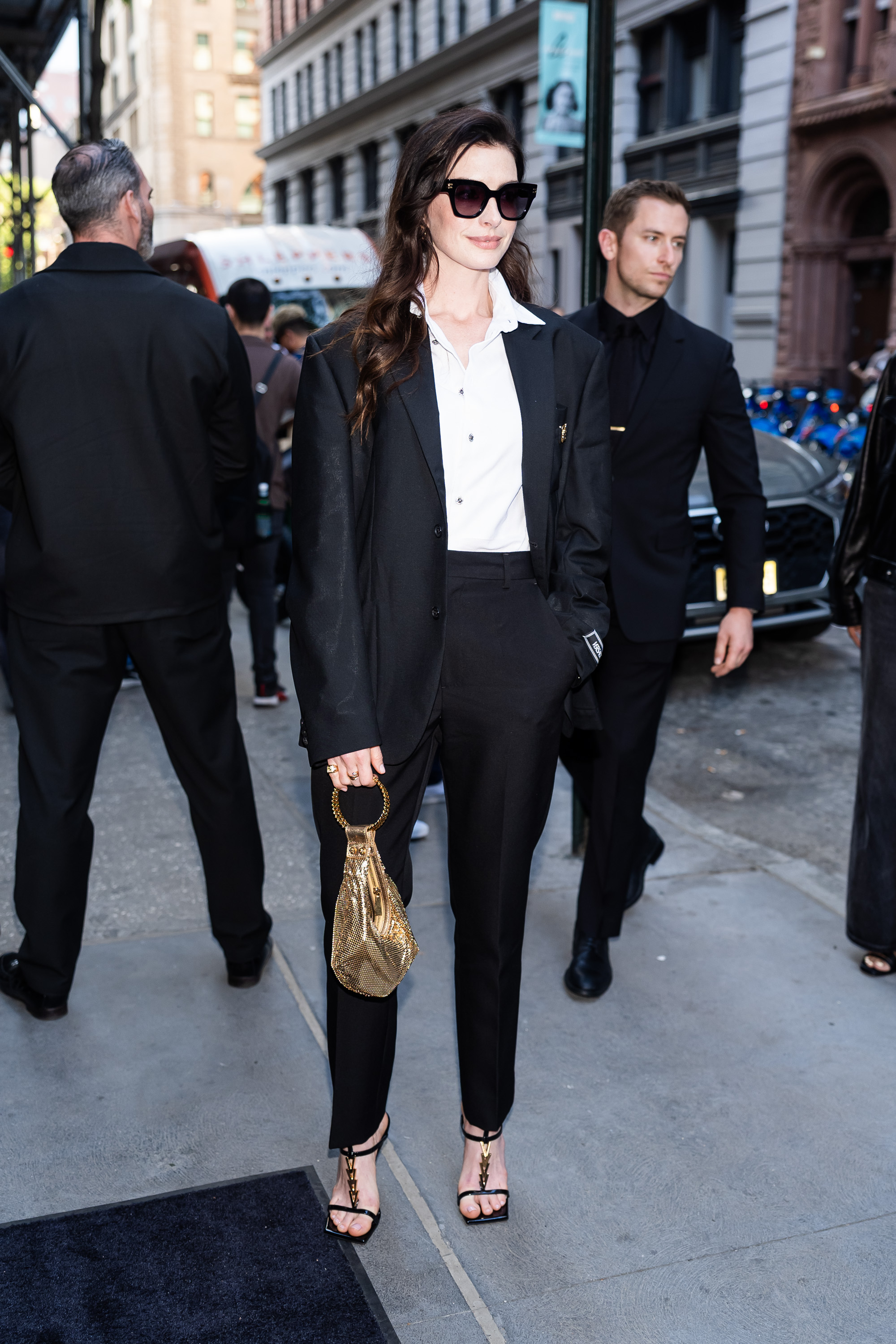 Anne Hathaway wearing a Versace suit and a Versace bag