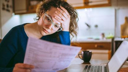 A woman looks through her bill in frustration.