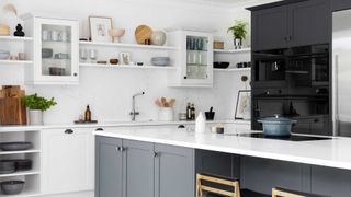 grey and white kitchen with wall units and glass fronted wall units and white work surfaces