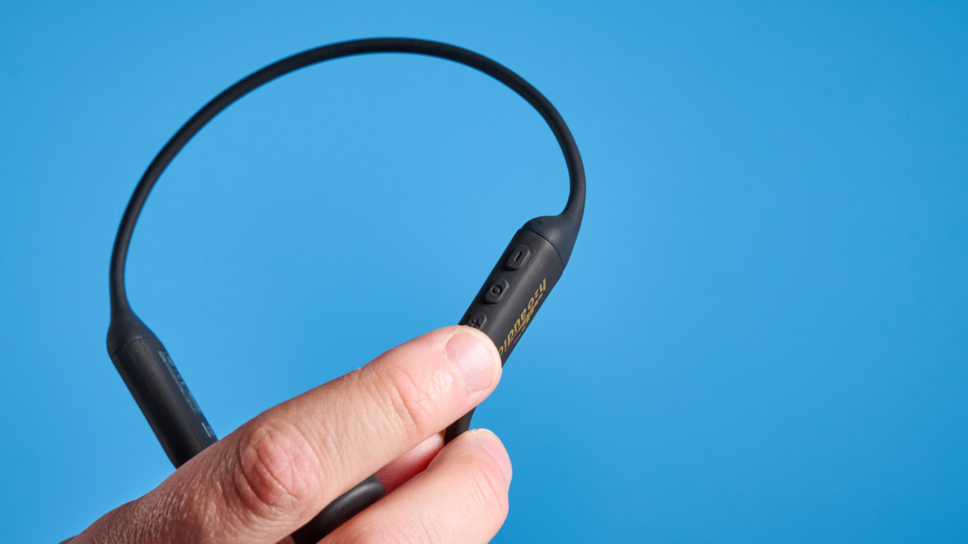H2O Audio TRI 2 PRO headphones photographed in front of a blue background
