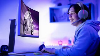 A gamer uses a new Philips Evnia monitor and headphones