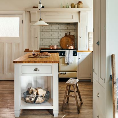 A cream shaker kitchen with a vintage stool and cutting boards