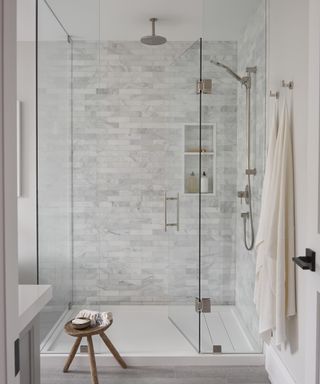 An ensuite bathroom with a large marble-backed shower