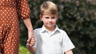 Prince Louis holds Catherine, Princess of Wales's hand as he arrives for a settling in afternoon at Lambrook School