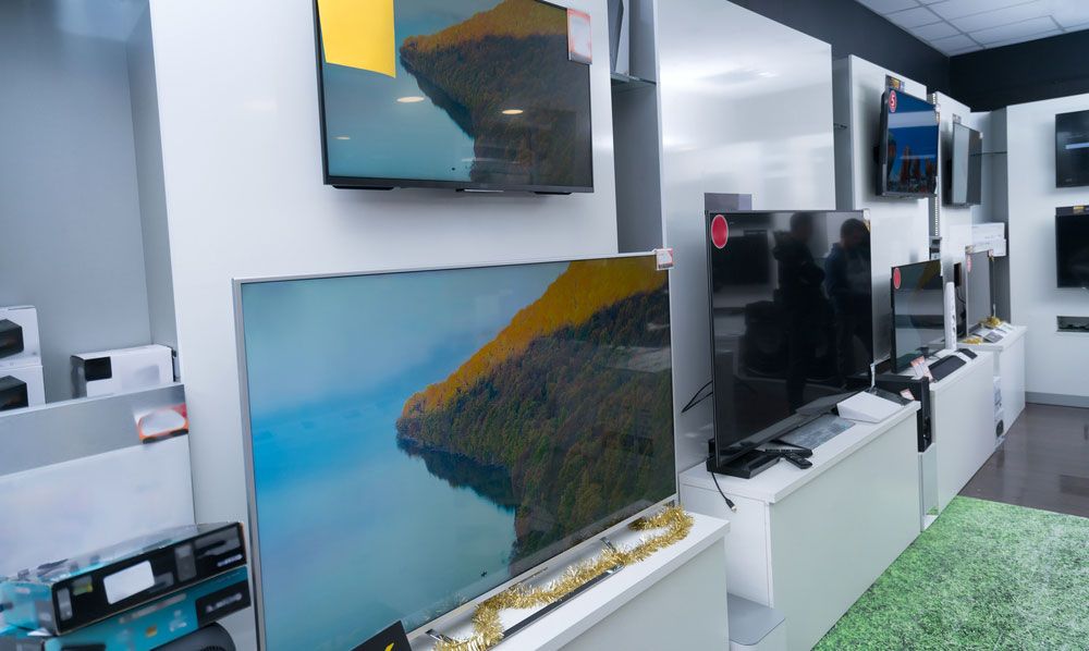 Flatscreen TVs on display in a retail store.