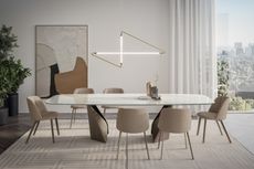 a modern dining room with a cross sculptural chandelier above the table