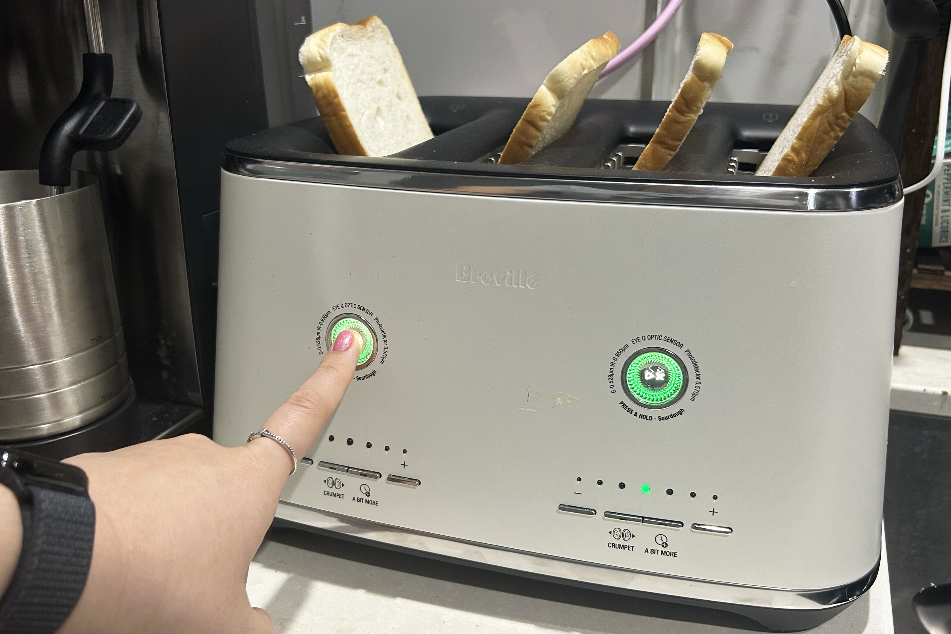 Toast in Breville Eye Q toaster with hand touching button