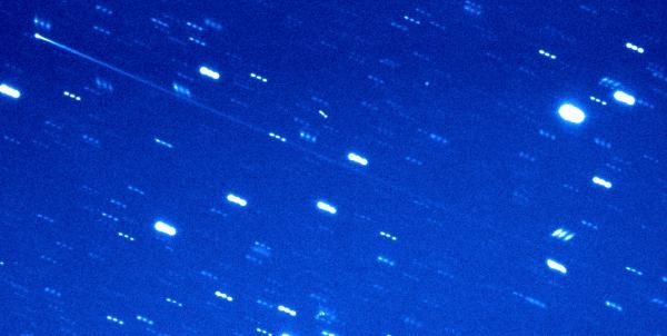 A composite image shows the passage of 2005 QN173, a rare active asteroid. The nucleus is in the upper left corner of the image; the tail streaks diagonally across the frame.