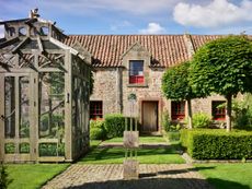 Fig 1: The courtyard garden, with its aviary and the front door of the house. Broadwoodside, East Lothian, photographed by Paul Highnam for Country Life. ©Country Life