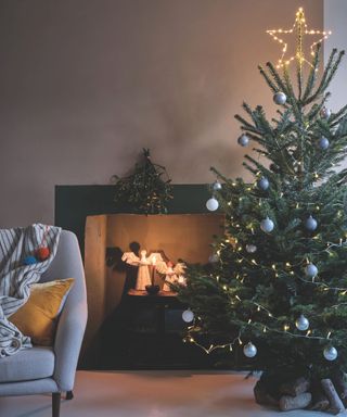 minimal living room with a fireplace and light up angels and a small christmas tree decorated with logs