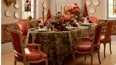 Green floral tablecloth with red chairs and fall floral arrangements