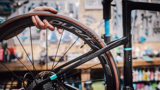 Mechanic fitting a Shimani Dura-Ace wheel to a Chapter2 TOA frame