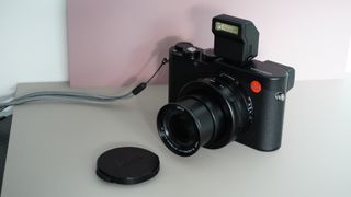 The Leica D-Lux 8 on a grey and pink background